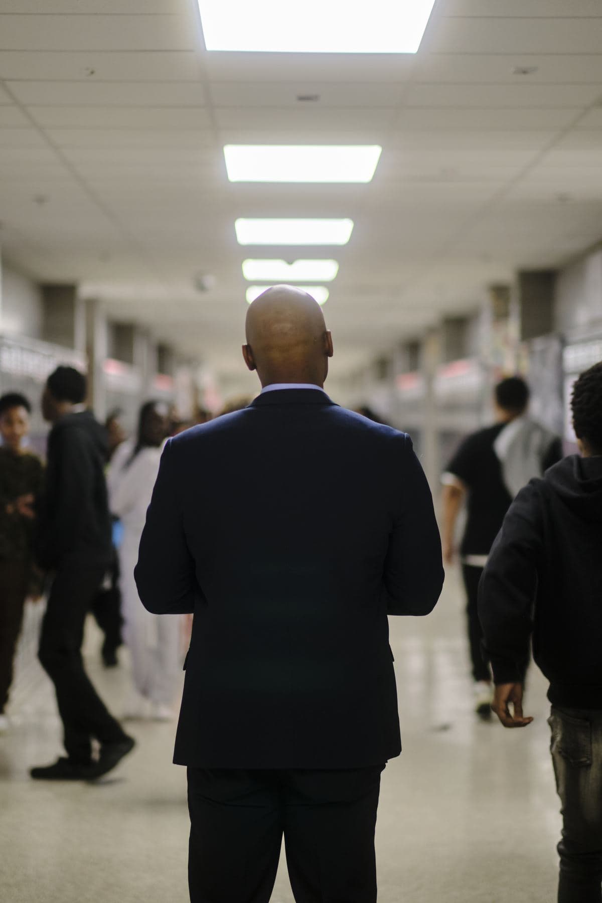 A principal walking a school hallway